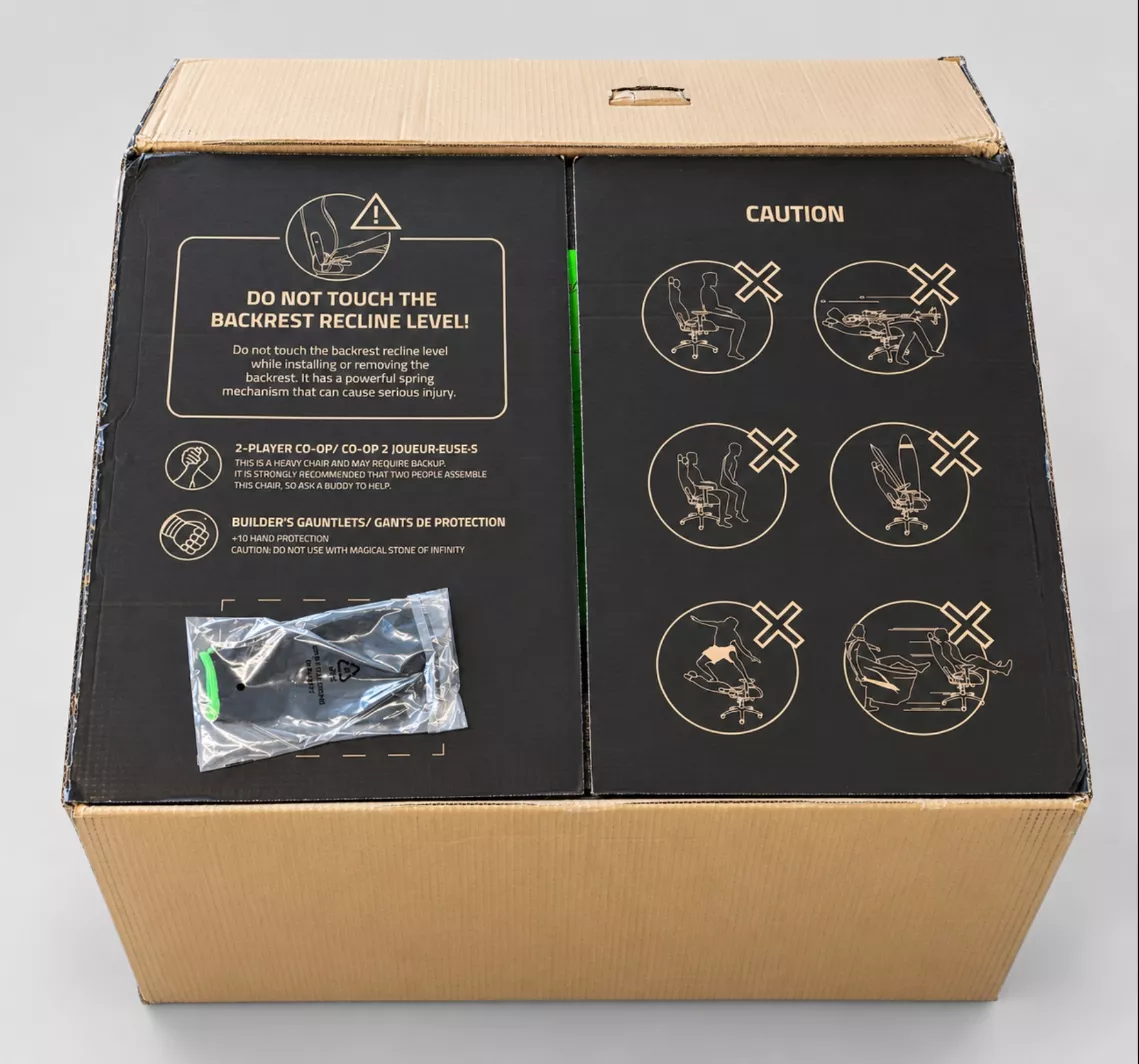 Dessus du carton Razer Iskur V2 NewGen avec les avertissements et les gants fournis